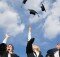 High school graduates throwing their mortarboards in the air